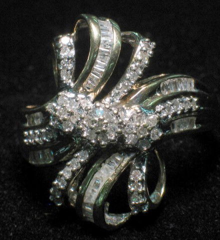 10K Multi-level Diamond Cluster Fashion Ring: 4.6g, size 8, Eye catching ribbon-bow design. 3 top level 7 diamond clusters (21 stones) and 64 lower level baguettes and round brilliants on bands of the ribbon design.