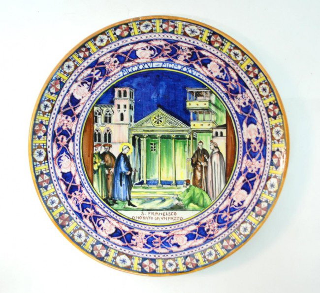 Italian Faience Charger Depicting St. Francis: 14" diameter. Hand Painted image of a man laying down his cloak for St. Francis to walk on with the words "S. Francesco Onorato Da Un Pazzo" translated roughly to Frances Honored by a Madman.Roman num