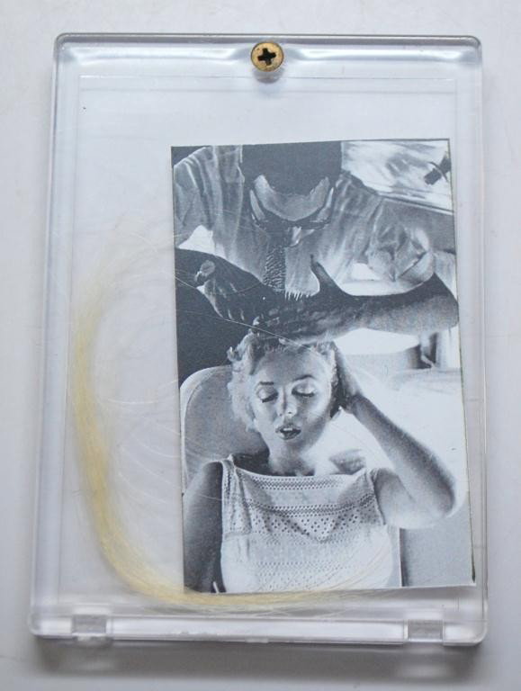 Marilyn Monroe Strands of Hair with COA: A strand of Marilyn Monroe's hair encased in between two hard plastic slabs. Includes a notarized letter of authenticity from well known Marilyn Monroe friend, collector, and expert James Haspiel who