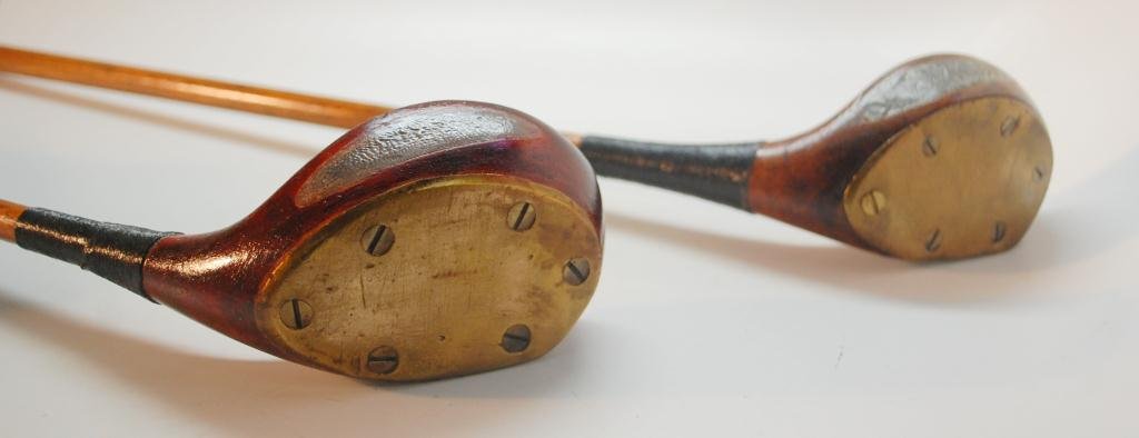 2 Transition Head Brassies: Transitional heads. Both with Full Brass Sole plate and Large Leaded back weight. One club stamped "A. Mercer" which is likely the golf pro who fashioned this head. Owner initials also prominent "F.S.