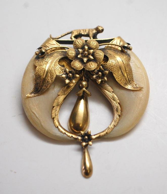 Edwardian Tiger Claws and Gold Brooch: Pair of opposing tiger's claws surmounted by a gold tiger figure atop flower and leaves, with two drop pendants. Approximately 10K Gold. Approximate weight 14 g.