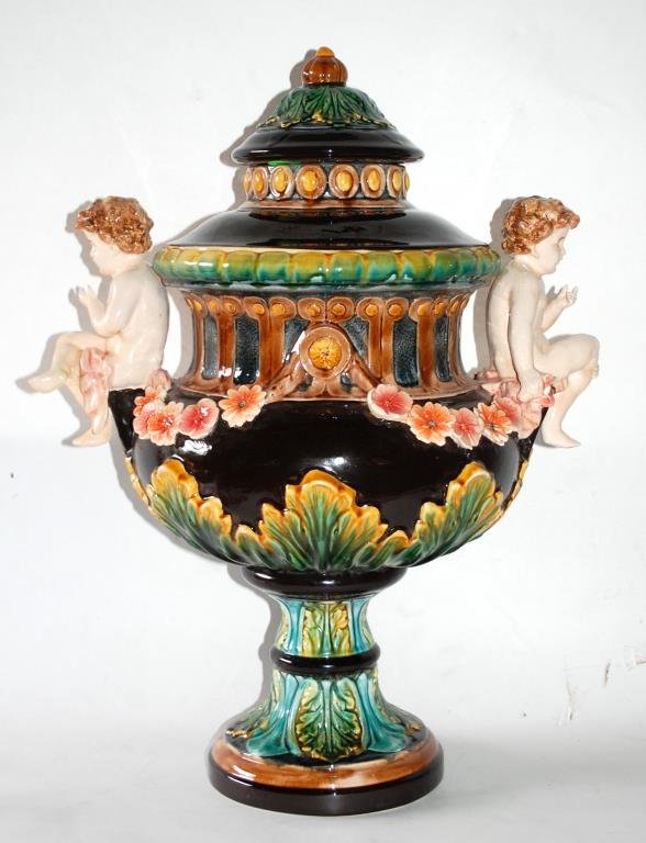 Monumental Majolica Urn Attributed to Minton: Monumental Cobalt, Yellow, and Turquoise Lidded two-handled Urn, each handle modeled as putti w/ a garland of flowers and leaf design. Bold colors. Bottom marked within the porcelain 1789.24 1/2"