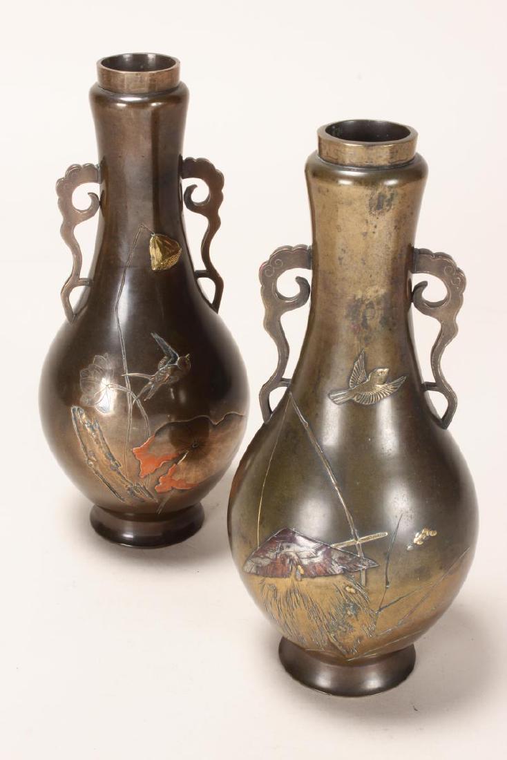 Good Pair of Japanese Bronze Inlaid Vases,: of garlic form, flanked by cloud scroll handles, the body decorated with birds in flight and hidden figure with bow and arrow, impressed marks to base, h 22cm
