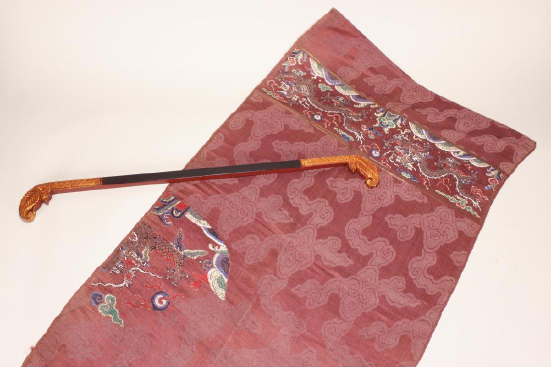 Chinese Late Qing Dynasty Formal Court Skirt Panel: c.1890, brown and maroon panel, embroidered with dragons chasing a flaming pearl and a section of a dragon, on decorative hanger, 132cm x 73cm Provenance: Collection of Judith Rutherford