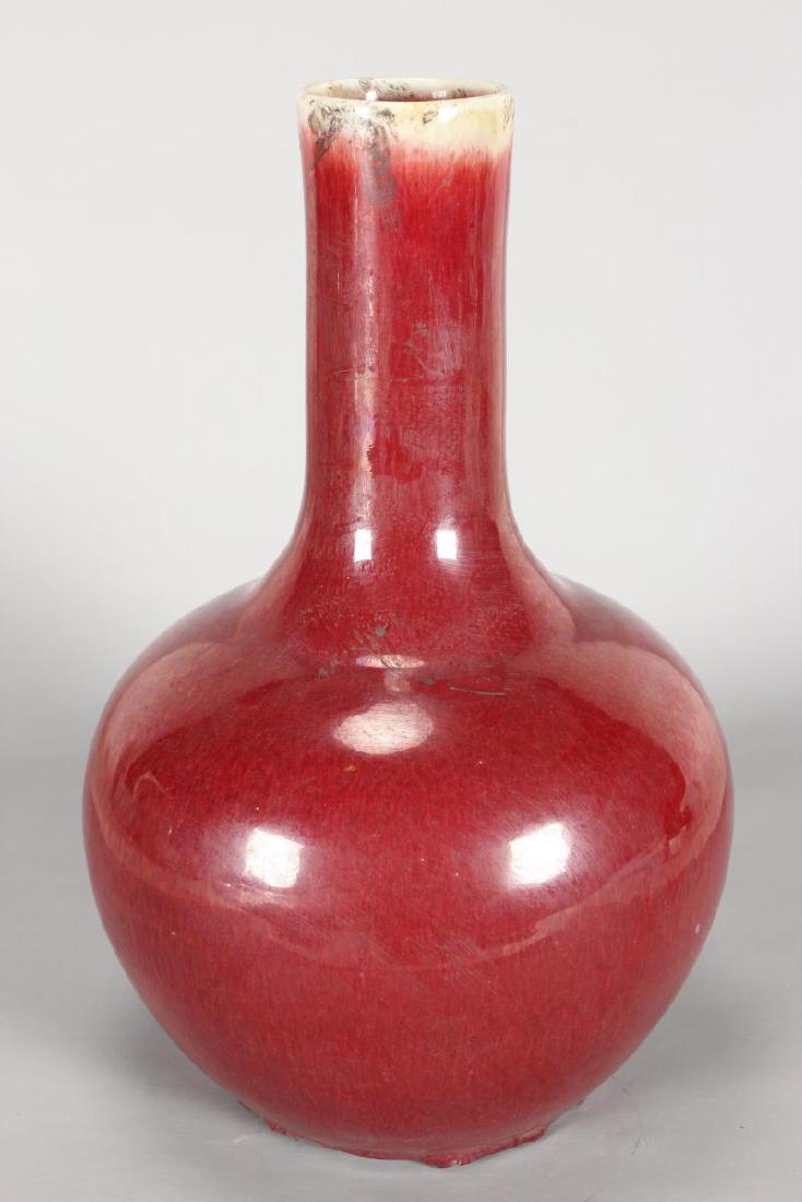 Chinese Sang de Boeuf Vase,: of baluster form with a cylindrical neck, in tones of red with a beige rim, h 35cm