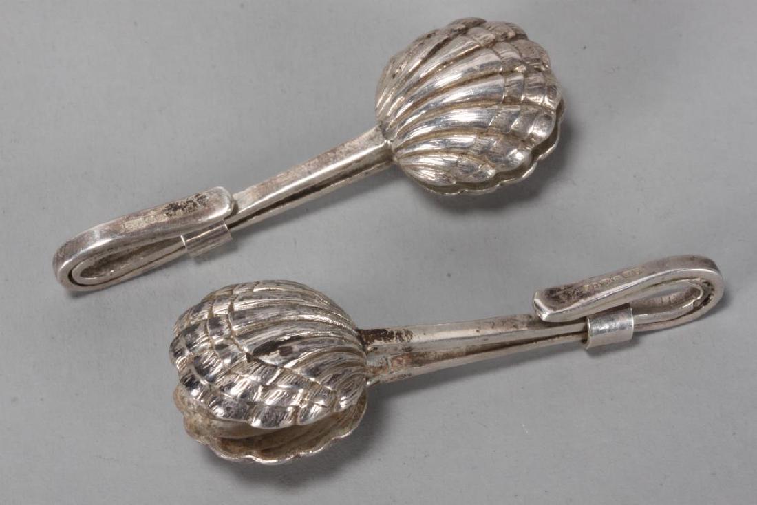 Pair of Sterling Silver Napkin Clips,: hallmarked London, 1956, CCP (Sibray, Hall & Co Ltd (Charles Clement Pilling), in the form of clam shells, with hooked ends and cylindrical fasterners, total weight 16gms, l 5cm (2)