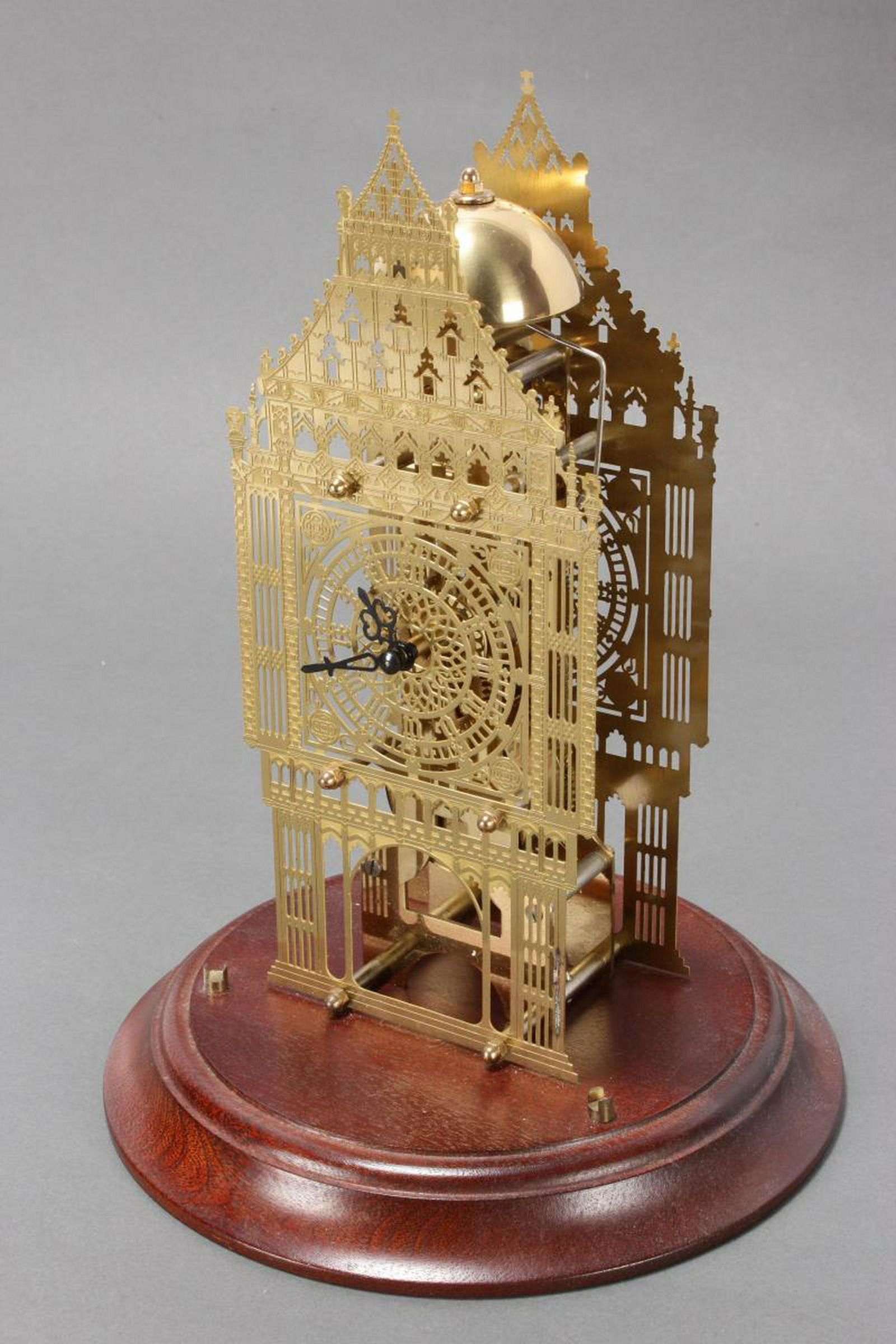 Big Ben Skeleton Mantle Clock,: set with pierced panels, with the movement centre, above a swing pendulum and key, raised on wooden stand with glass dome cover