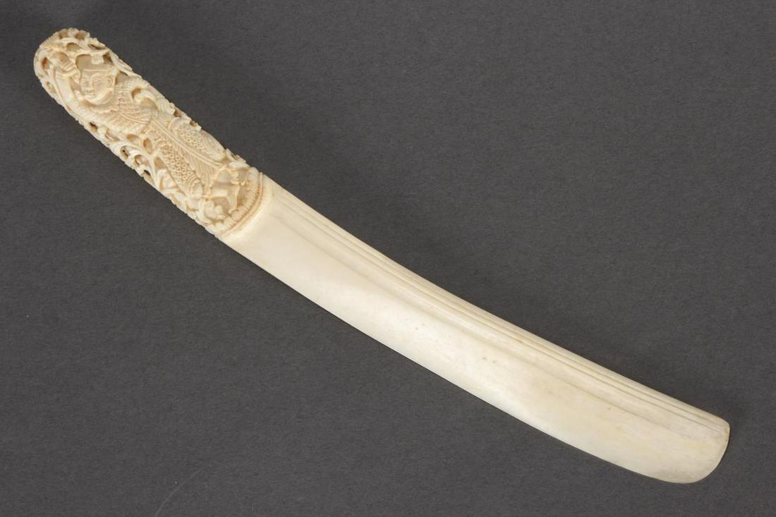 South East Asian Bone Letter Opener,: the handle carved with dancers and acanthus motifs, with curved blade, l 25cm