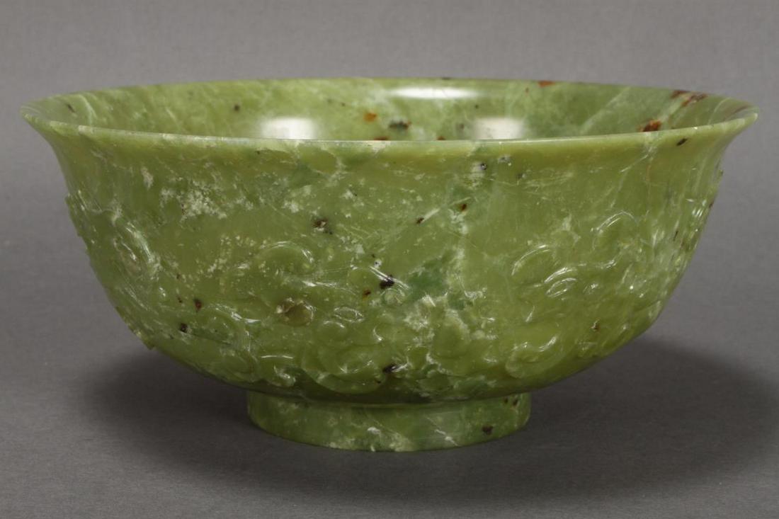 Good Chinese Carved Jade Bowl,: with a flared lip and sloping sides, carved with a frieze of dragons in relief, in tones of green, brown and white, the whole raised on a circular foot, d 20cm Provenance: Dr. Merna Marie Torrington C