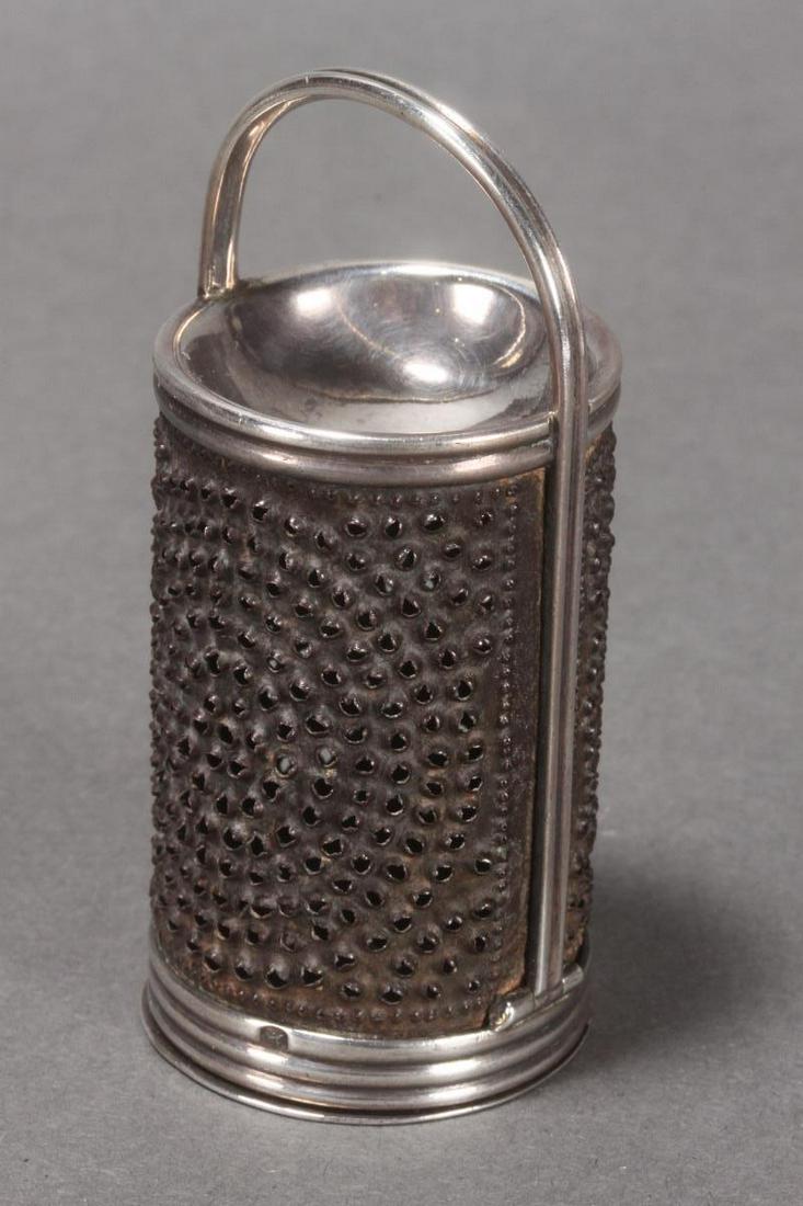 Wonderful George III Sterling Silver Nutmeg Grater: hallmarked, 1732, IR (John Robins), with cylindrical steel grill, the top in the form of a bowl, in a reeded frame with loop handle and hinged base, total weight 45gm, h 8cm and w 3.5cm