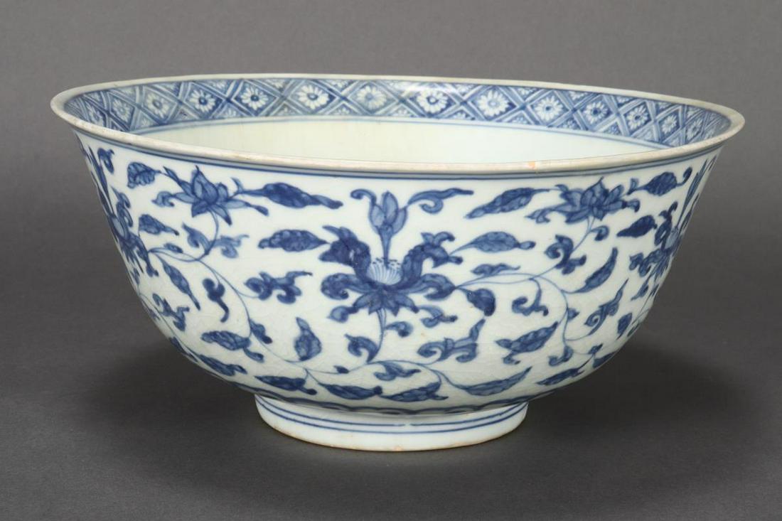 Chinese Late Ming Dynasty Blue and White Porcelain: with flared lips above deep sides, decorated with central roundel of a flower, surrounded by flower head border, the exterior with lotus scroll raised on circular foot, with earlier six character mark