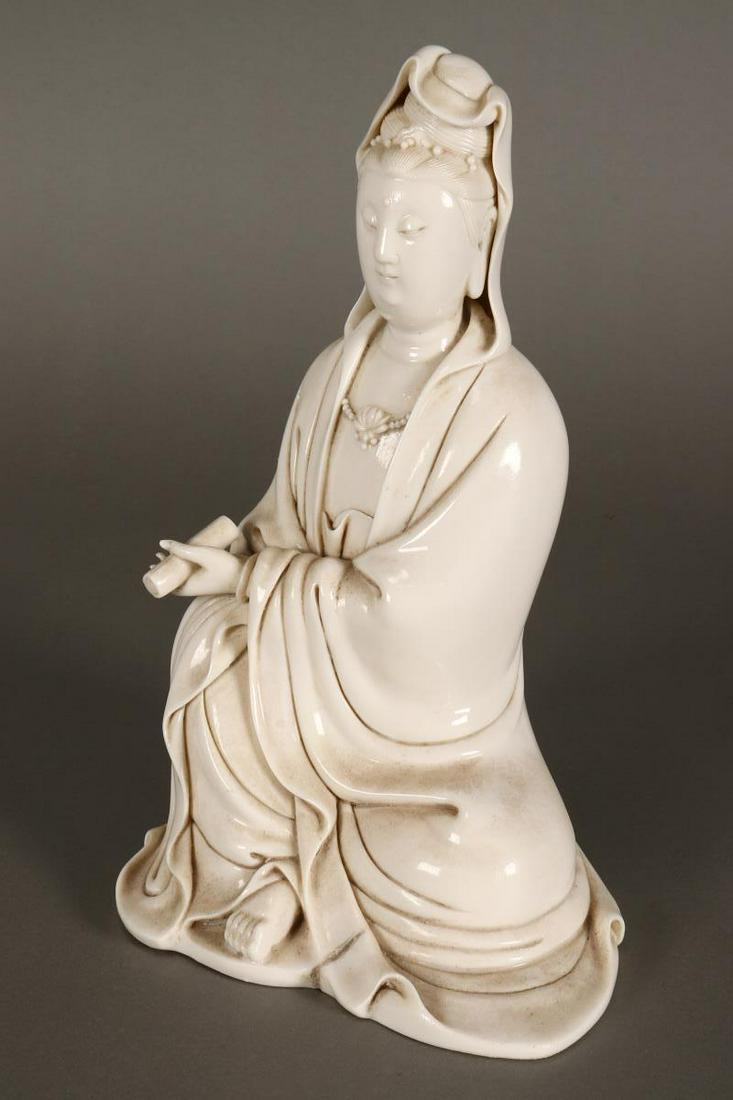 Chinese Blanc de Chine Figure Of Kwan Yin,: depicted seated in robes, with legs crossed holding scroll in left hand, incised mark to back and interior, h 27.5cm