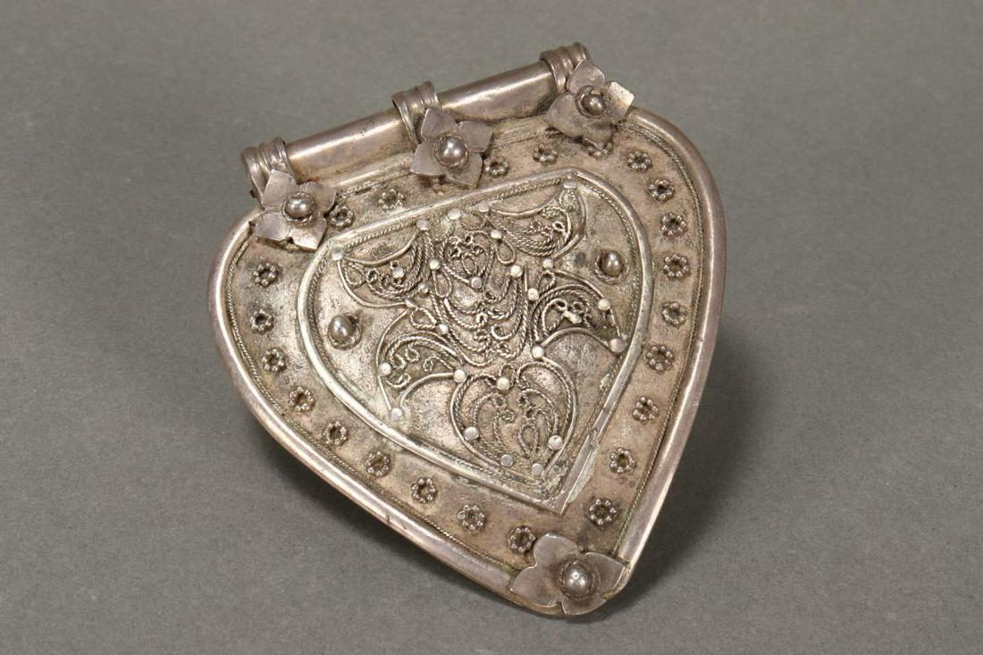 Makassan South of Sulawasi Modesty Panel,: of heart form, with filigree decoration to centre, surrounded by rosette motifs, h 7cm Provenance: J L Smith Collection, Far South Coast NSW
