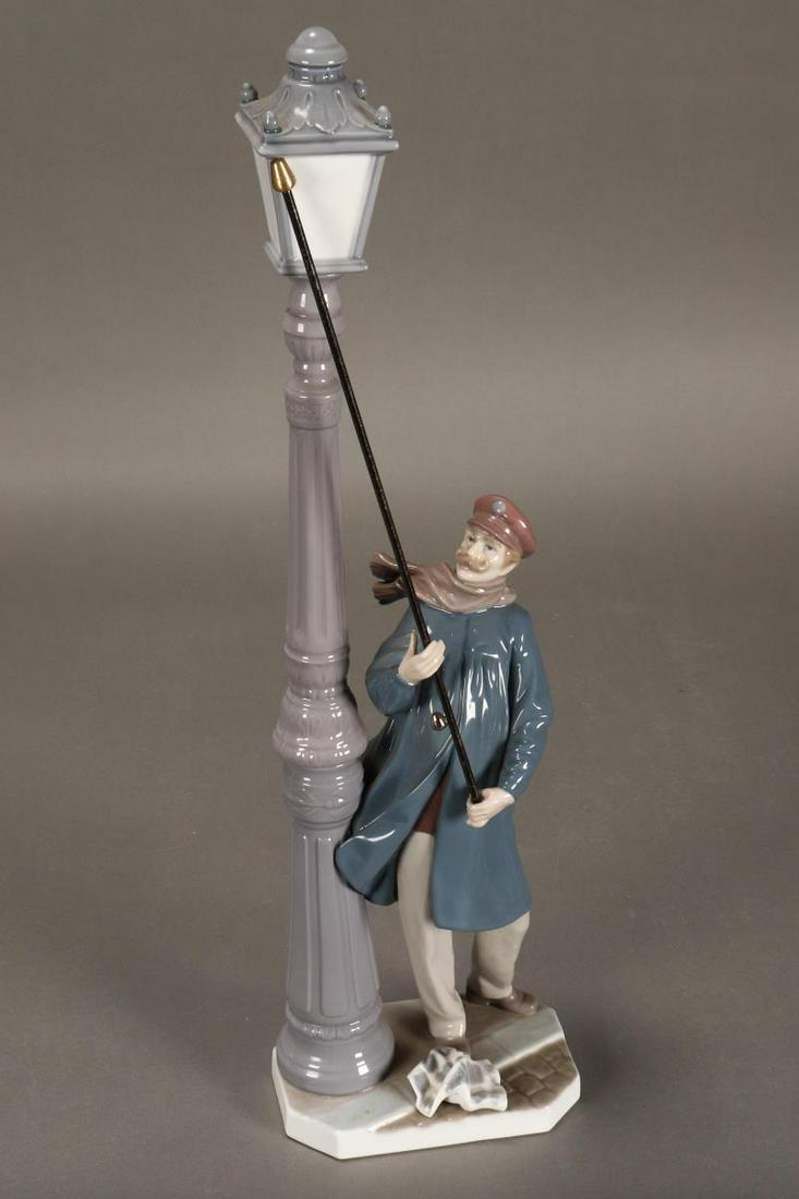 Lladro 'Lamplighter' Porcelain Figure,: depicting a man lighting a street light, in tones of blue, brown and grey, height 48cm
