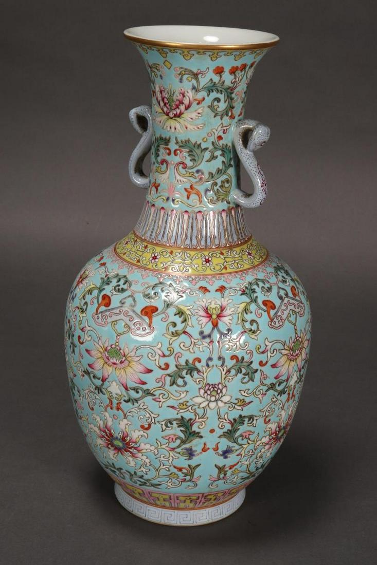 Chinese Twin Handled Porcelain Vase,: of baluster form with a flared lip, set with twin ruyi head handles, decorated with polychrome flowers on a blue/ green ground between palmette, ruyi head, lappet and key-fret borders, accented with g