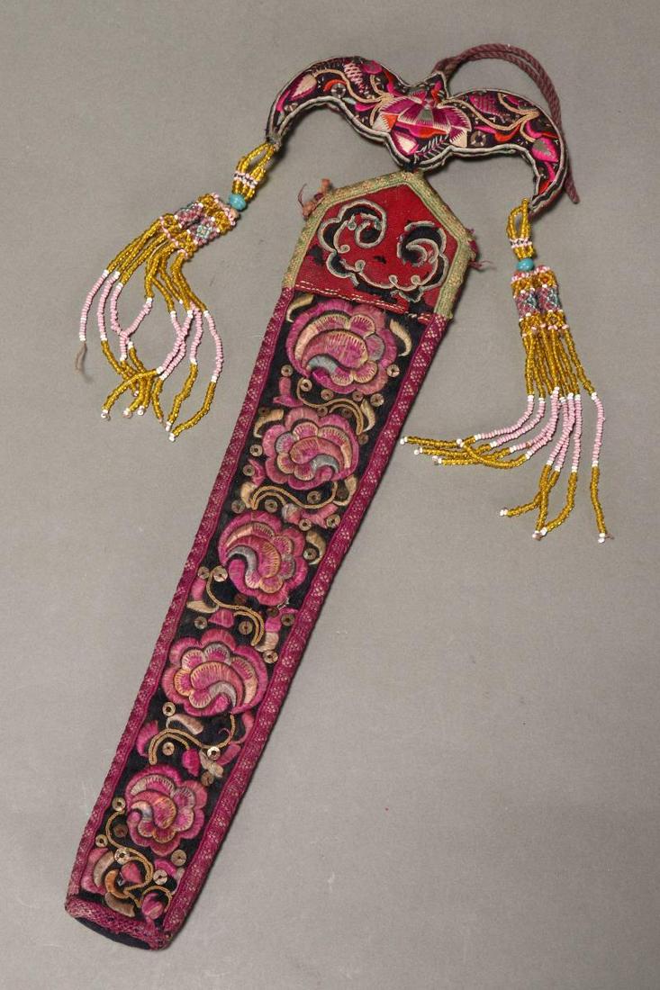 Chinese Late Qing Dynasty, Early 20th Century: Fan Holder, beautifully embroidered with flowers and foliage, in tones of lavender, yellow and green, with bat motif and beaded tassels, length 30cm Provenance: Collection of Genevieve Cummins Publish