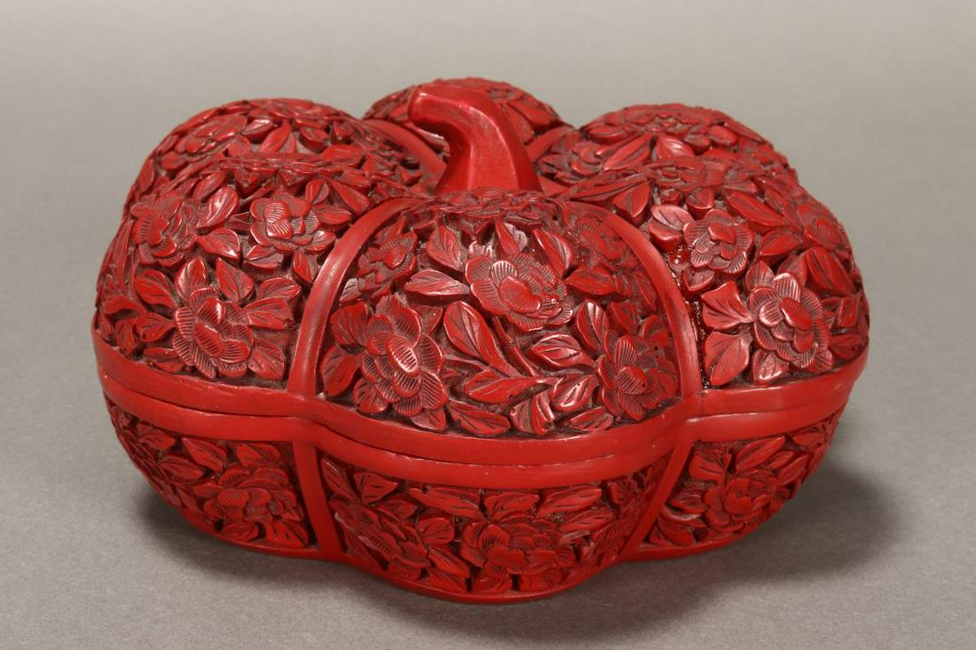 Chinese Pumpkin Shaped Box and Cover,: in cinnabar tones, the pumpkin shaped decorated with flowers and foliage, opening to black interior, diameter 16cm