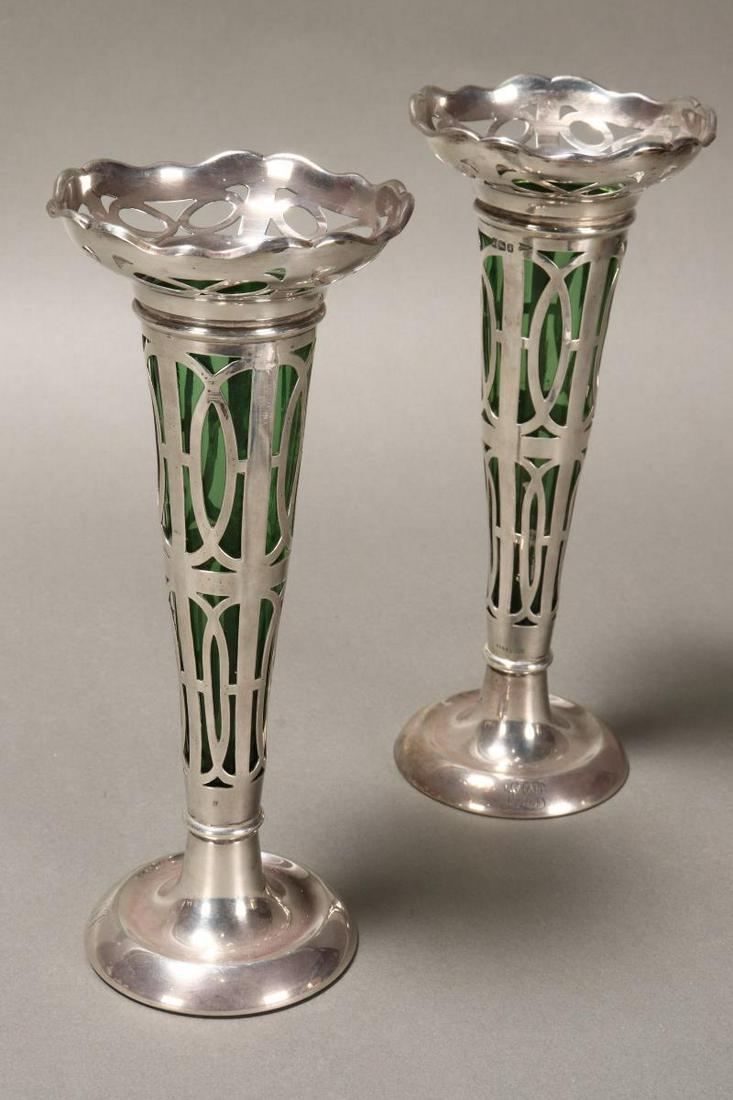 Wonderful Pair of Edwardian Sterling Silver: Trumpet Vases, hallmarked Sheffield, 1908, Walker and Hall, with a shaped lip above a tapering body, with pierced decoration, on a circular foot, set with green glass liners, height 19cm (2)