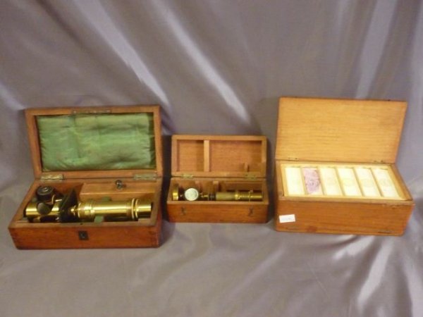Two Victorian Brass Microscopes,: together with a box of slides from St. Georges Hospital, London