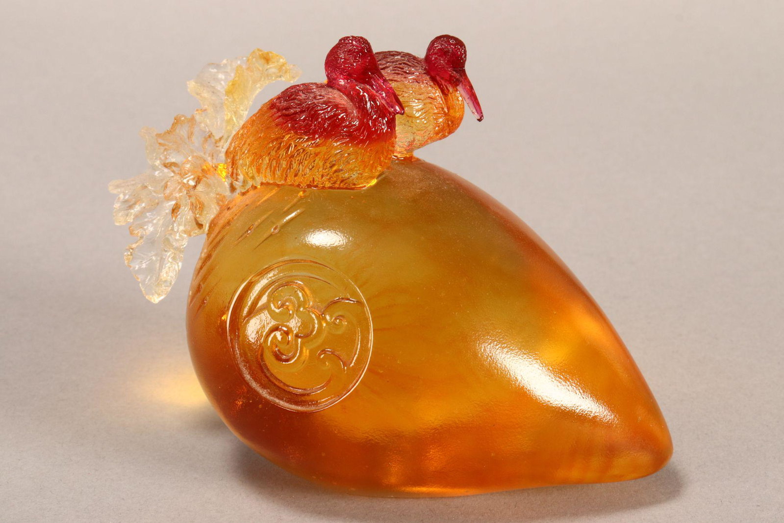 Taiwanese Tittot Art Glass Figure Group,: in the form of two ducks atop a fruit, with roundel design to side, in amber and clear tones with red accents, signed Tittot to base with character marks, height 10cm x length 14cm