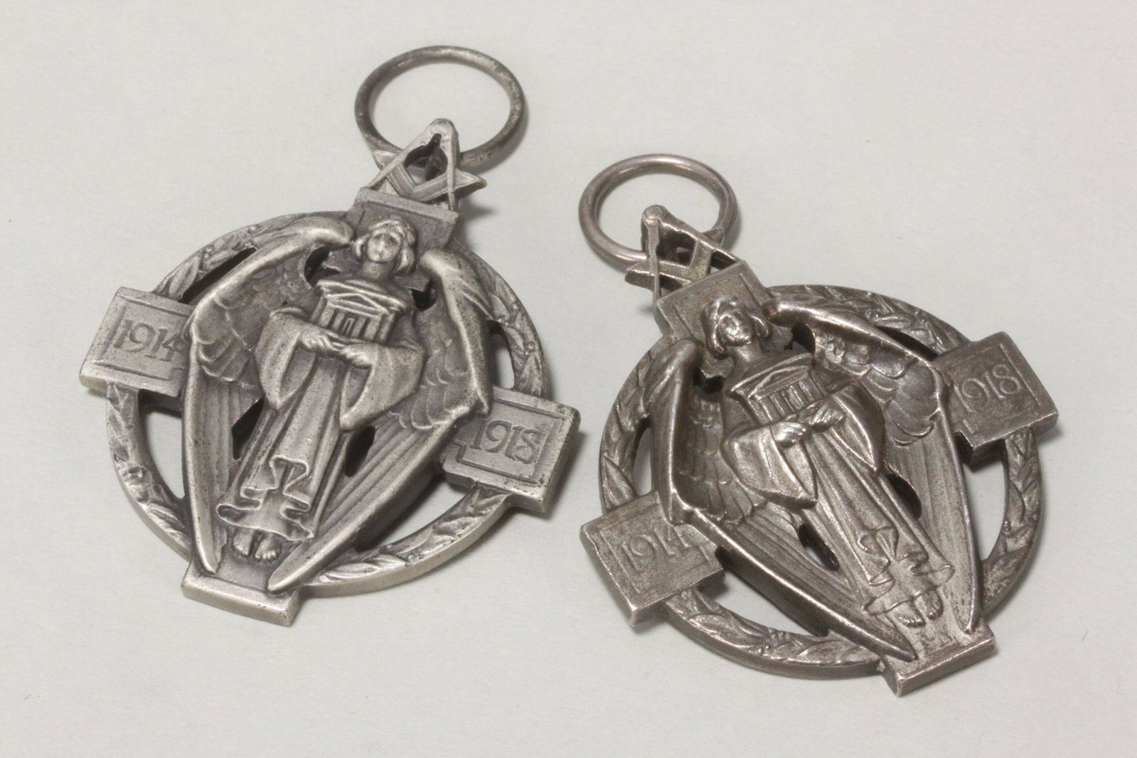 Two Sterling Silver Masonic Medals,: hallmarked Birmingham, 1927/1933, with compass and set square above an angel, flanked by dates 1914-1918, with inscribed names verso, total weight 56gm (2)