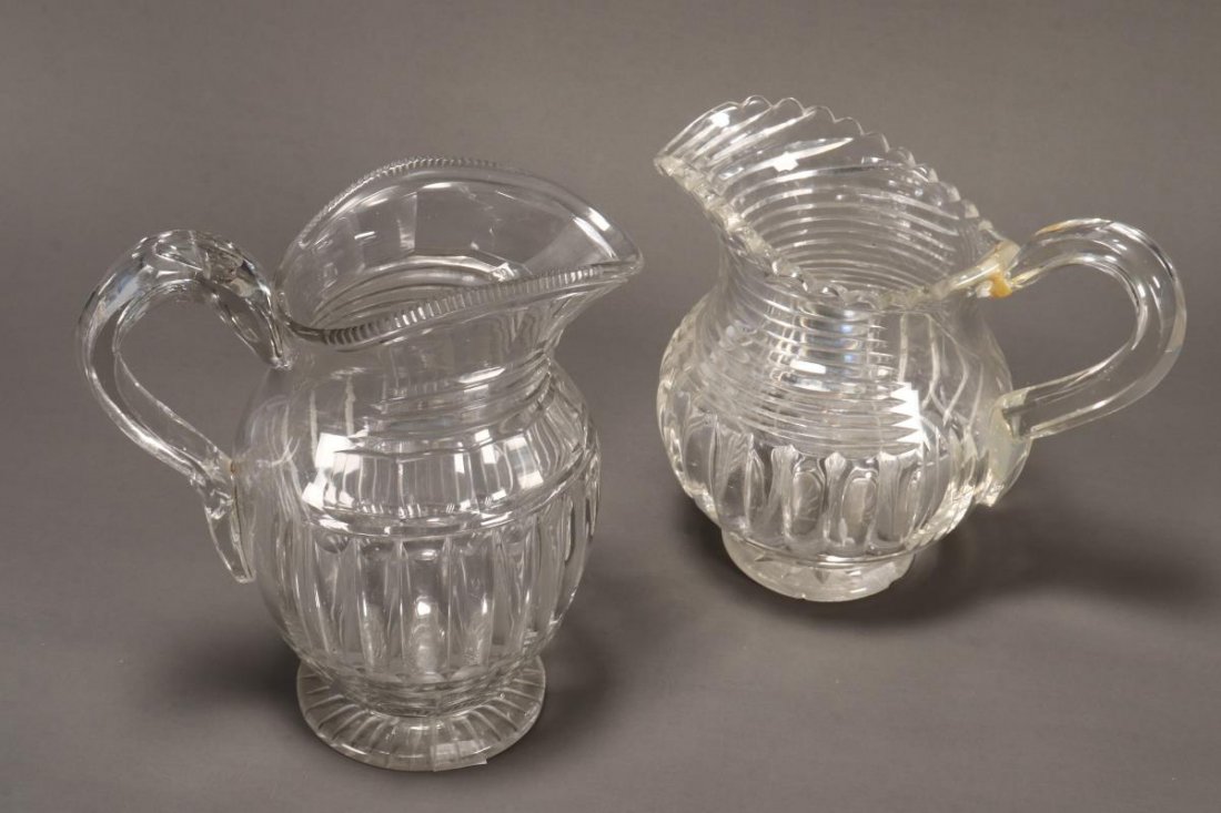 Three Graduated Regency Water Jugs,: all with loop handles and stepped cut glass body on a heavy circular star cut body, a/f, height 22cm, 19cm and 16cm (3)