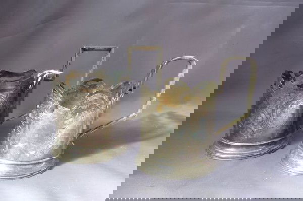 Pair of 19th Century Russian Silver Tea Cups,: with an angled handle and shaped and pierced body, with a engraved leaves and foliage, (2)