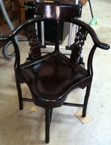 Chinese Ebonised Corner Chair, c.1950: with a horseshoe shaped back rail leading to twin pierced vertical waist rails and saddle seat all raised on circular turned legs united by stretchers, h 73cm