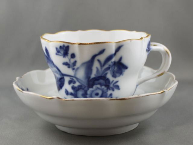 Early 19th Century Meissen Porcelain Cup and: Saucer, of deep form with serpentine edge and decorated with underglaze blue flowers and accented in gilt, crossed sword marks