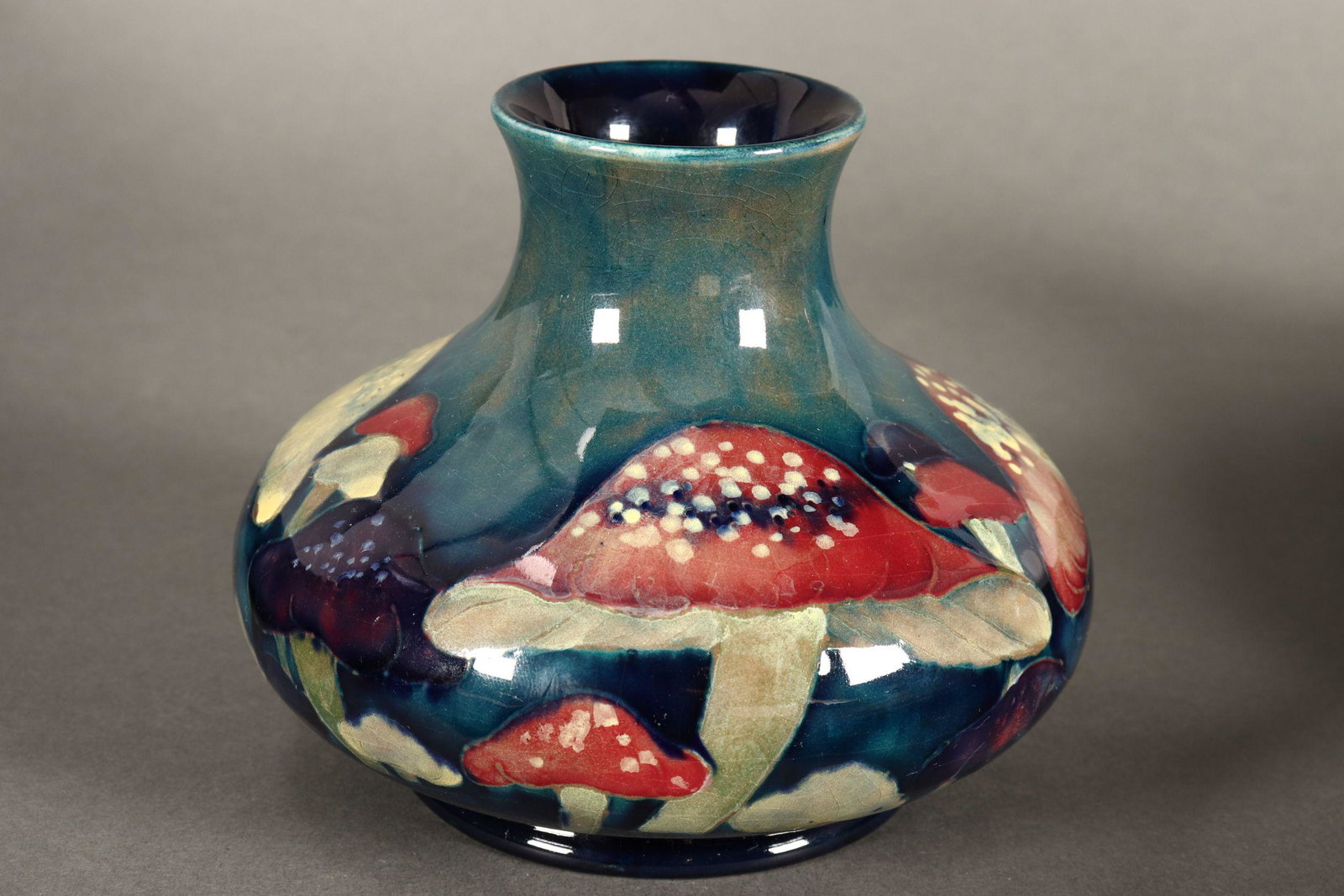 William Moorcroft 'Claremont' Pattern Vase,: c.1918-26, of squat baluster form with slightly flaring rim, decorated with toadstools on a mottled blue/ green ground, signed with impressed 'Moorcroft', 'Made In England' and 'M32' to base, height 1