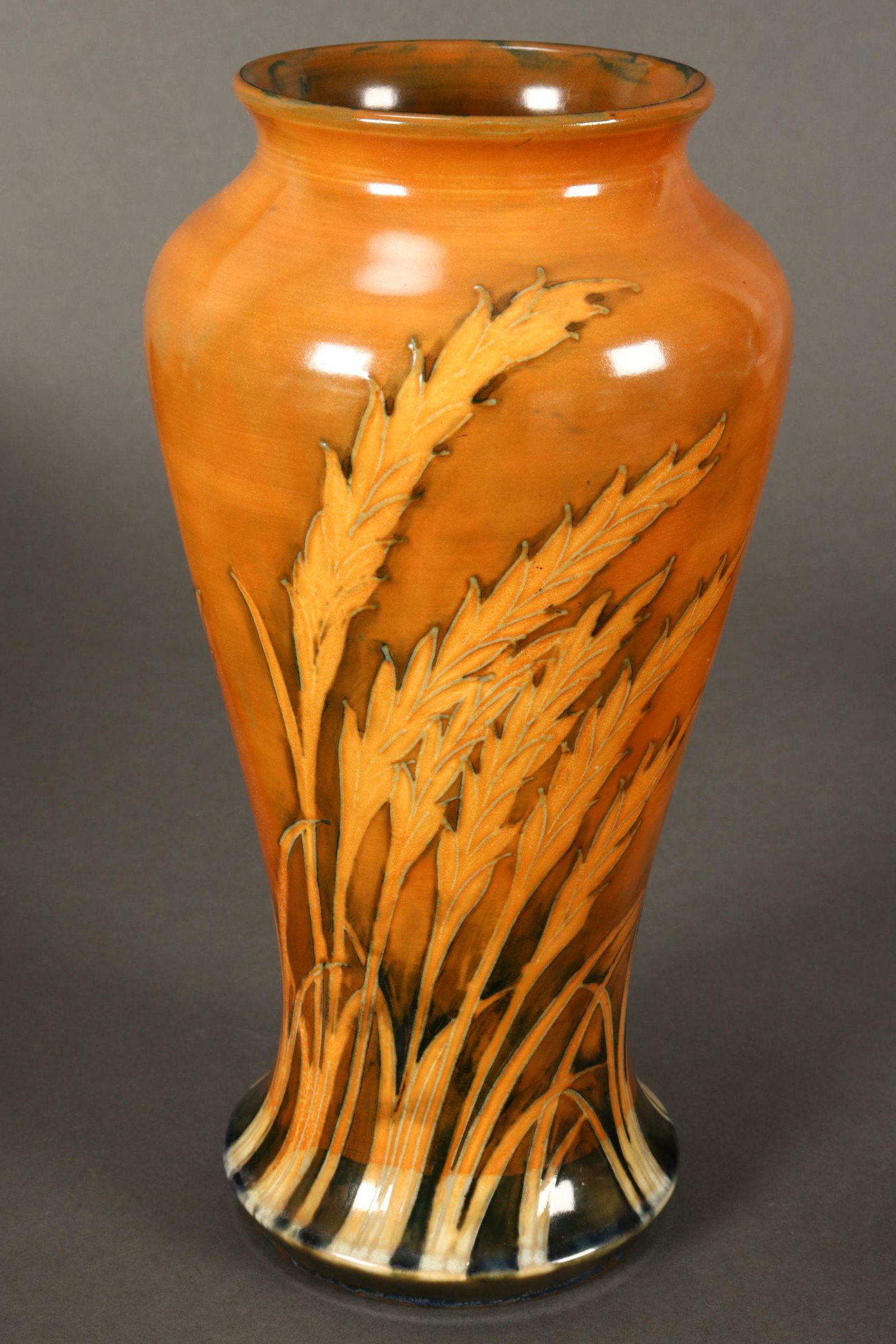 William Moorcroft 'Waving Corn' Pattern Vase,: c.1935, of baluster form, decorated with sheaths of corn in ochre tones, signed to base and impressed 'Made in England' and 'Potter to H.M The Queen', height 23cm