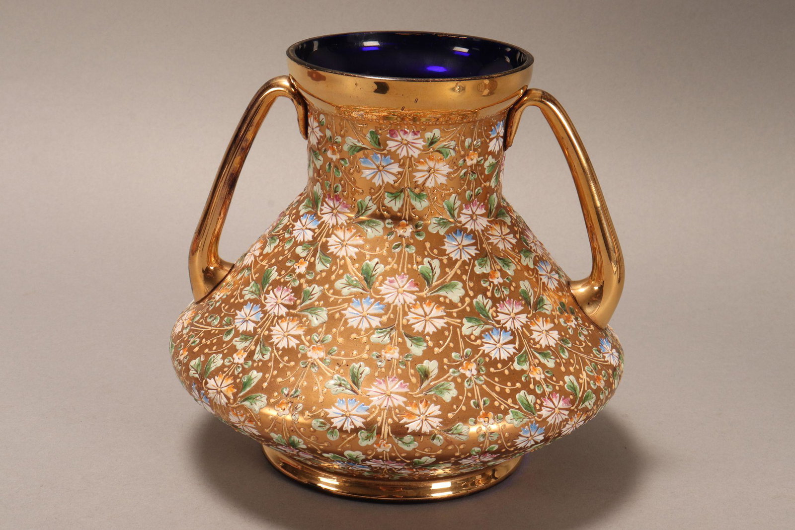 Fine 19th Century Moser Twin Handled Glass Vase,: of squat form with a cylindrical neck, in cobalt blue crystal with all over gilt and enamelled flower and foliate decoration, height 16.5cm
