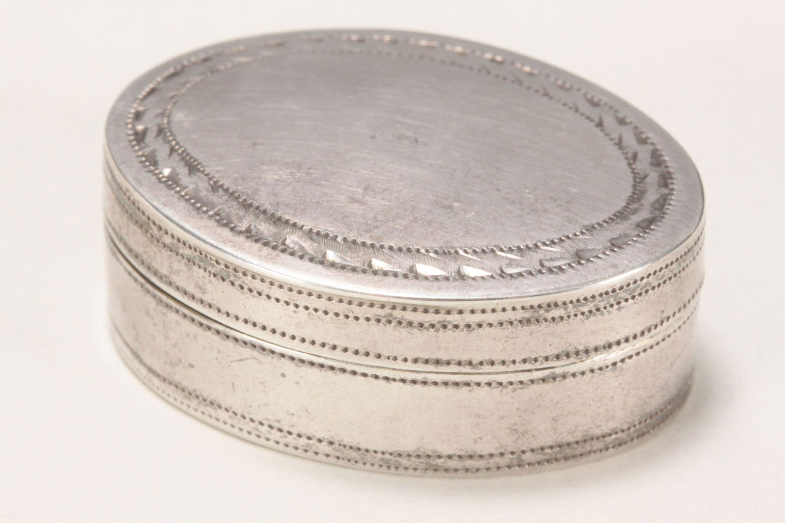 George III Sterling Silver Vinaigrette,: hallmarked Birmingham, 1799, IT (probably John Taylor), of oval form with bright cut decoration encircling the body, the hinged top cover opening to reveal a gilt wash interior with side hinged grate,