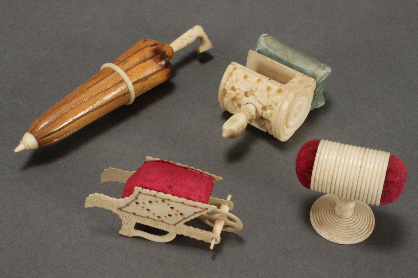 Four 19th Century Bone Sewing Implements: including pin cushion clamp, pin cushion wheelbarrow, umbrella needle case and double ended emery, (4)Published: Antique Boxes: Inside and Out, colour plate 556l