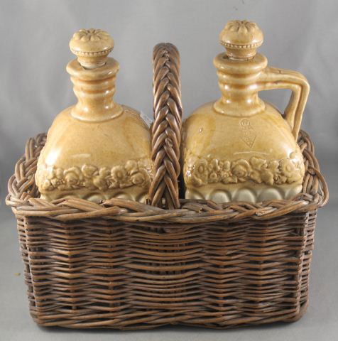 Pair Late Victorian Stoneware Decanters and: Stoppers, each decorated with slip glaze, with impressed registration mark, in original caned basket, (2)