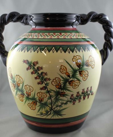 Large Henriot Quimper Ware Twin Handled Vase,: of baluster form, painted with wildflowers in tones of yellow, pink and green on a soft yellow ground, flanked by a pair of black glazed roped handles, h 27cm