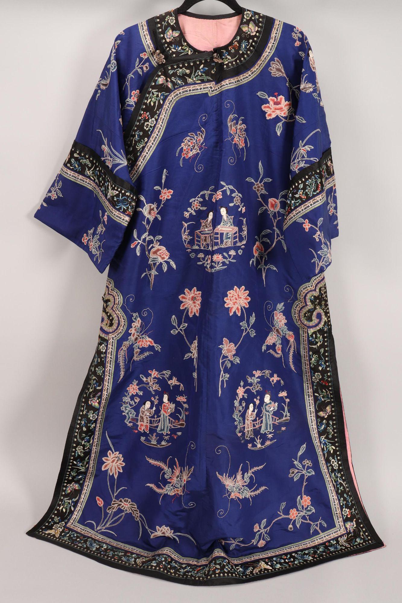 Chinese Embroidered Manchu Robe,: embroidered in Peking knot with roundels depicting two figures in various scenes, surrounded by flowers, butterflies and fruits in Peking knot, in tones of peach, blue and brown on a cobalt blue groun