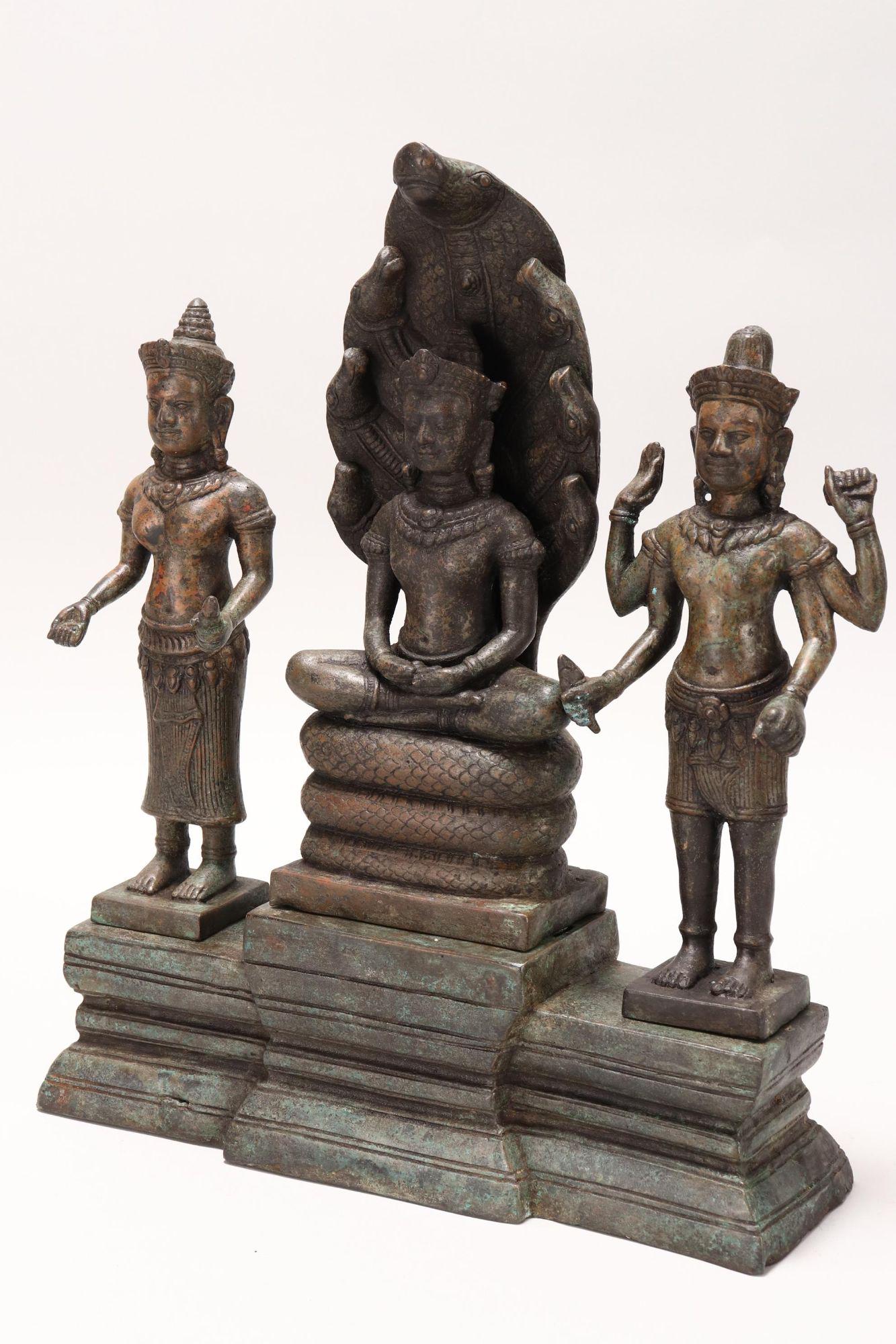 Khmer Bronze Buddhist Triad,: depicting seated Vishnu flanked by two forms of goddess Lakshmi, height 36cm and width 29.5cm