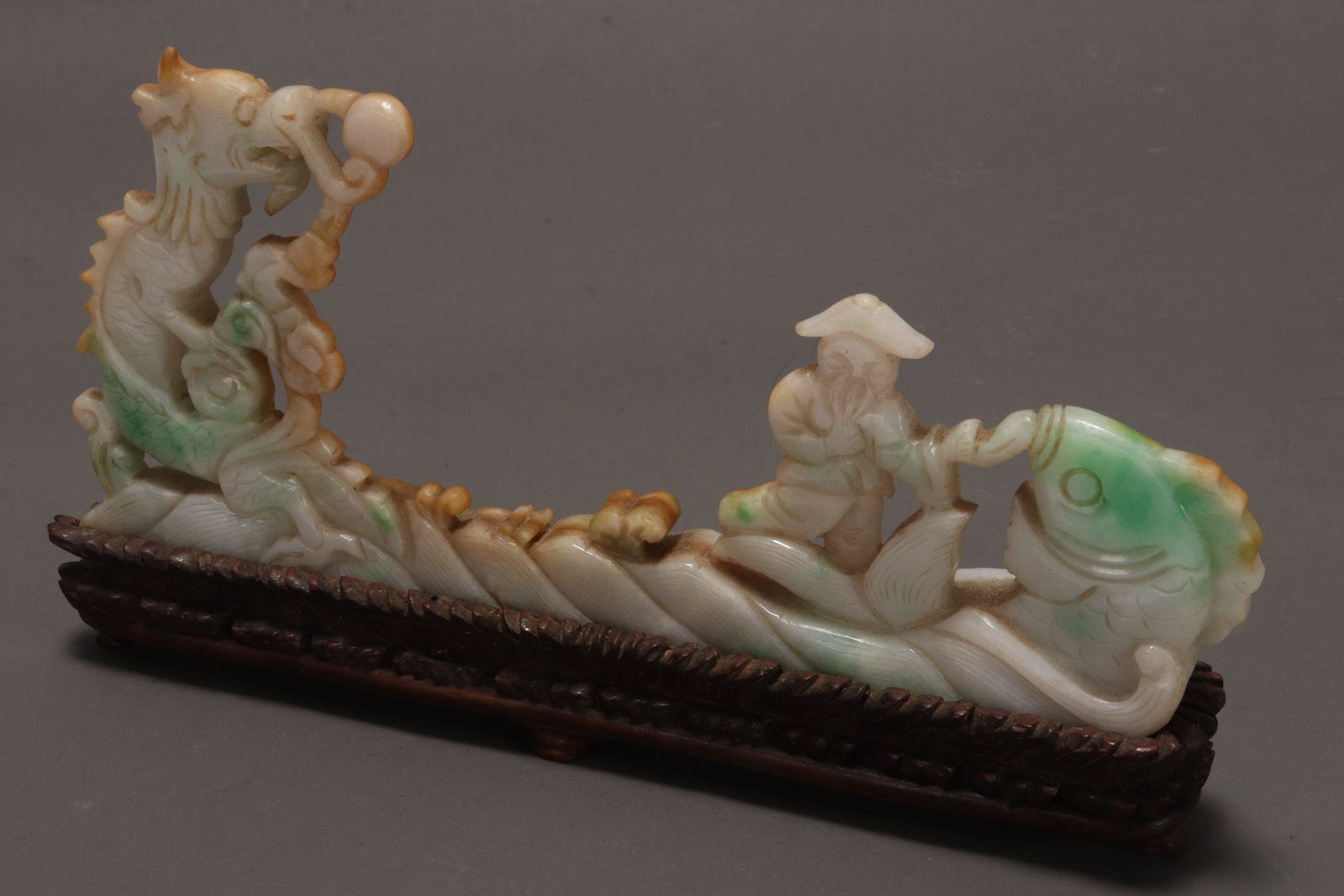 Chinese Carved Jade Figure Group,: carved in the form of a fisherman standing upon turbulent waves by a large fish, with rearing dragon to the other end, in tones of white, green and brown, height 7cm and length 16.5cm, together with w