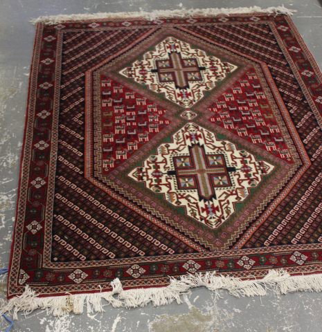 Syrian Rug,: of rectangular form, set with a four section diamond medallion, surrounded by stylised boarder in tones of red, cream and green, 295cm x 136cm