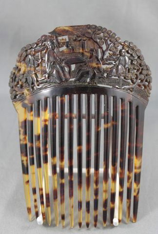 Good Chinese Qing Dynasty, Mid 19th Century: Tortoise Shell Hair Comb, with a demi lune shaped panel carved with a scene of two figures seated at a table, surrounded by three other figures in garden setting, above fifteen teeth, 13.5cm x 11cm