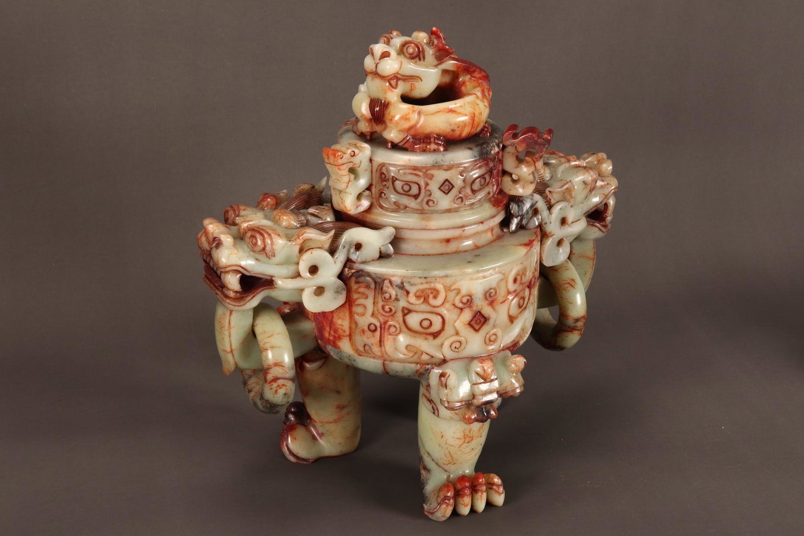 Monumental Chinese Carved Jade Censer and Cover,: the cylindrical cover set with a large dragon finial and three mythical handles, set above a larger cylindrical body decorated with Archaic motifs, with twin dragon handles each with a suspended drop 
