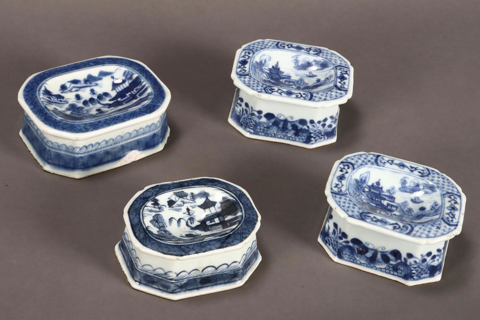 Set of Four Chinese Qing Dynasty Export Blue and: White Porcelain Salt Cellars, with shallow bowls and facetted bases, decorated with landscapes and flowers to the exterior, length (4)
