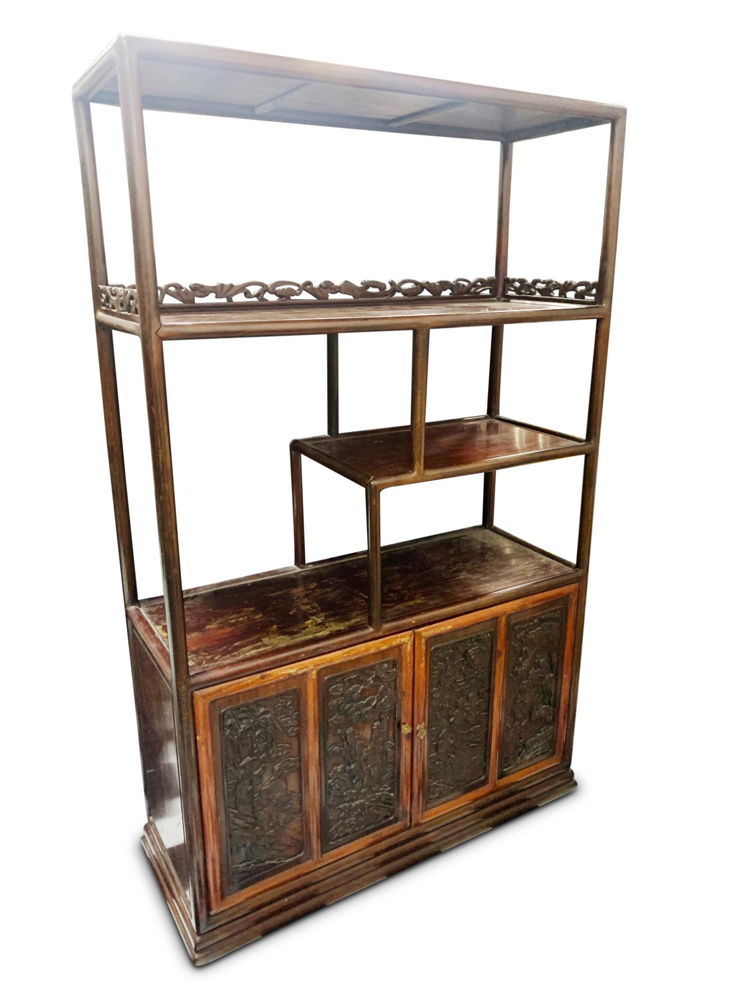 Chinese Hardwood Display Cabinet,: of rectangular form, with four open work shelves accented with carved bat and stylised cloud crest rail, set above two doors, each decorated with twin carved panels depicting scholars and attendants i