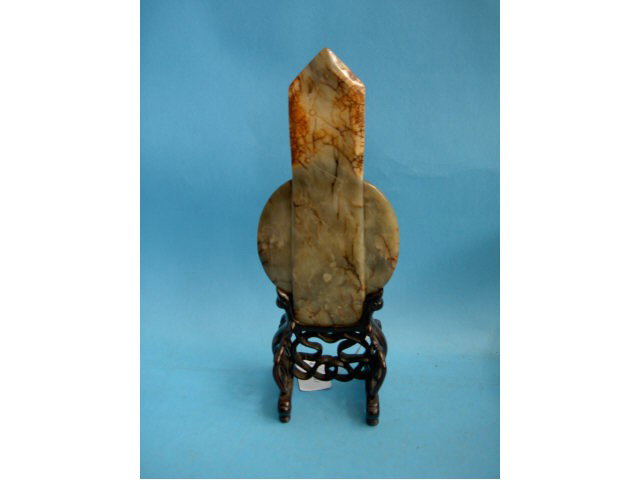 Striated Red Jade Kuei-Pi on Stand, Possibly Ming: Dynasty, modeled with a spear point top and carved with a stylised animal, above a circular carved panel, the resting upon and carved and pierced base, overall height 28cm
