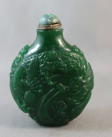 Stunning Chinese Emerald Green Glass Snuff: Bottle and Stopper, of pilgrim form, decorated with two carved rampant dragons disputing a flanming pearl, h 6cm