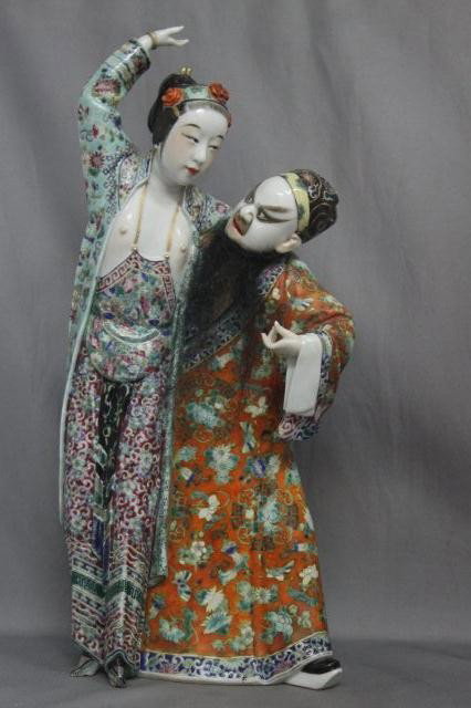 Chinese Qing Dynasty Erotic Figure Group,: Yeh Wain Deng, modelled in the form of a tall exotic lady, beautifully dressed in flowing robes her breasts exposed , leading on a gentleman wearing a court quality formal robe and heavy makeup and fl