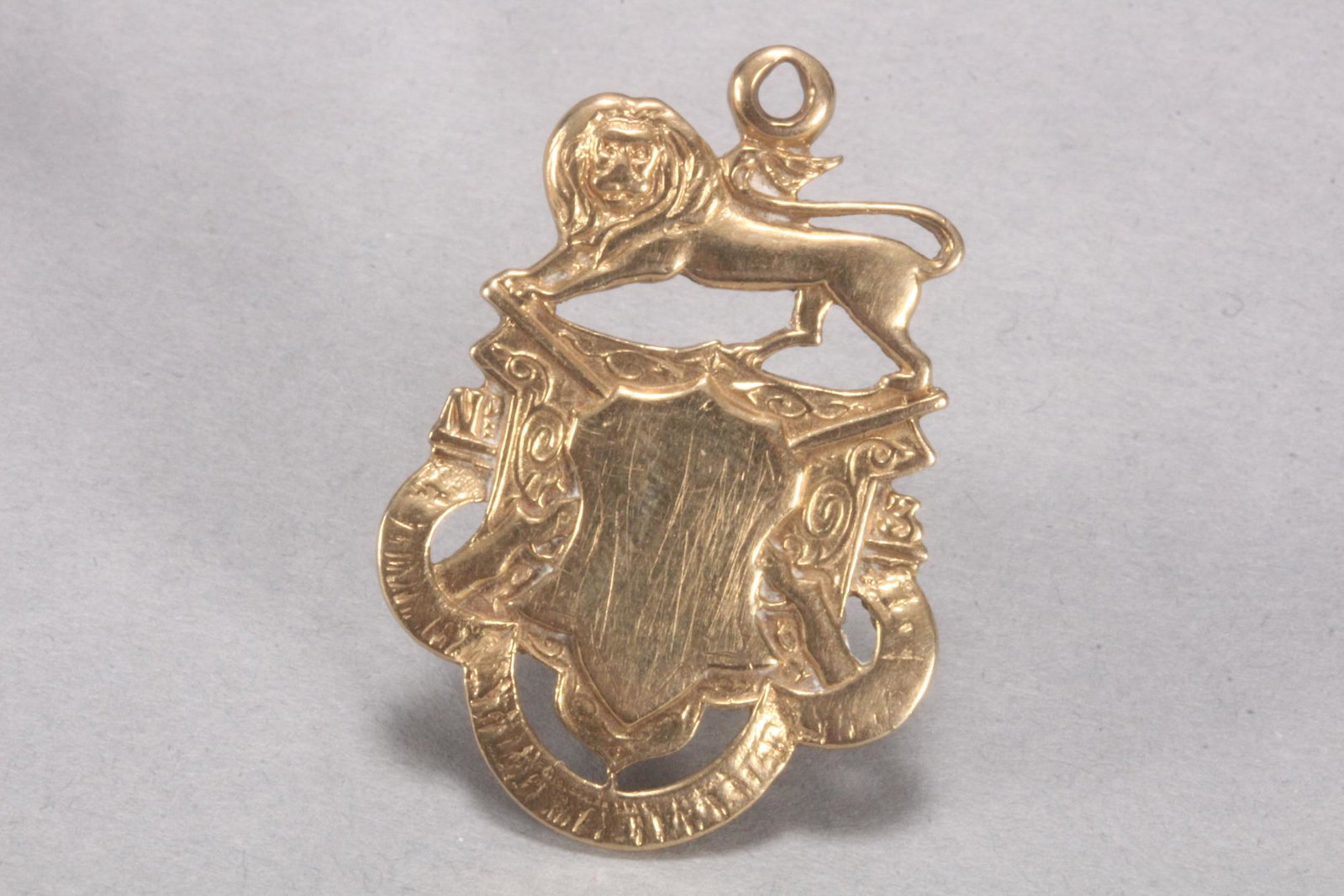 9ct Gold Shooters Pendant,: stamped verso 375, set with central shield before crossed rifles and surmounted with lion, total weight 7.72gm, height 3.7cm