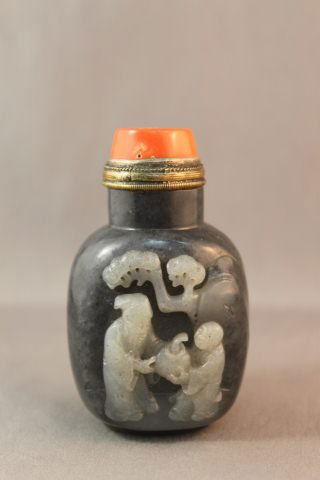 Chinese Black and White Jade Snuff Bottle and: Stopper, of baluster form, carved with a scholar and child under a tree, coral stopper, h 7.5cm