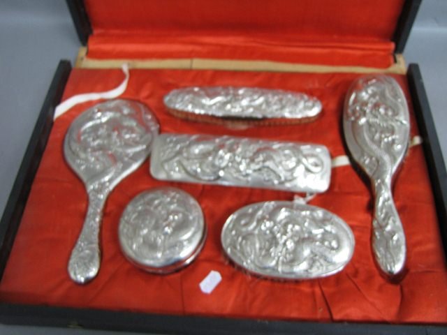 Chinese Boxed Brush Set,: in silver plate, each piece decorated with a rampant dragon, comprising of hand mirror, toilet jar and four brushes